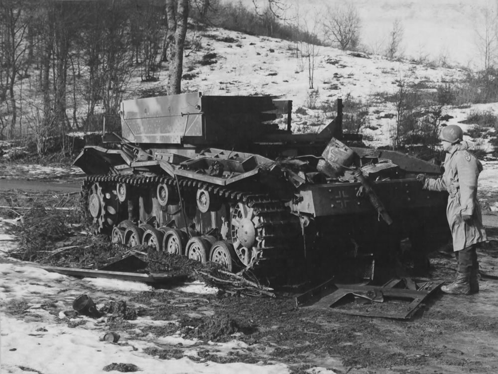 A USAF officer examines a knocked-out German Bergepanzer III tank-recovery vehicle abandoned in the Ardennes, January 1945.