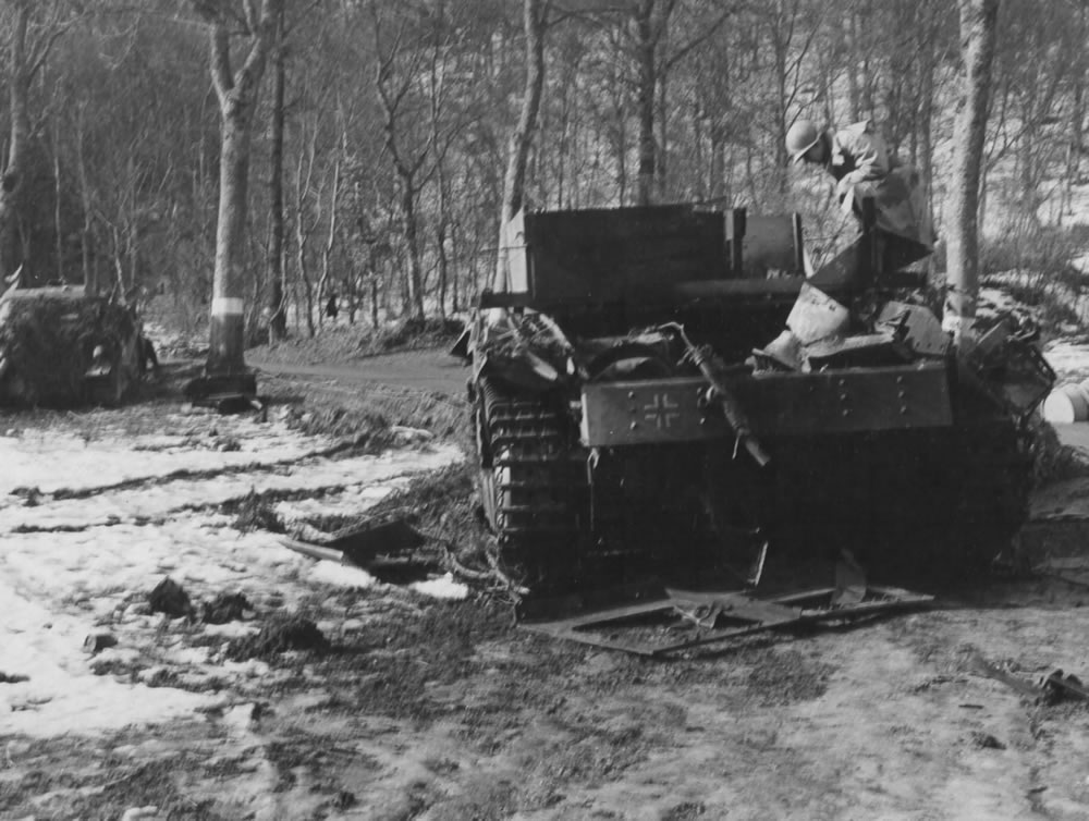 A USAF officer examines a knocked-out German Bergepanzer III tank-recovery vehicle abandoned in the Ardennes, January 1945.