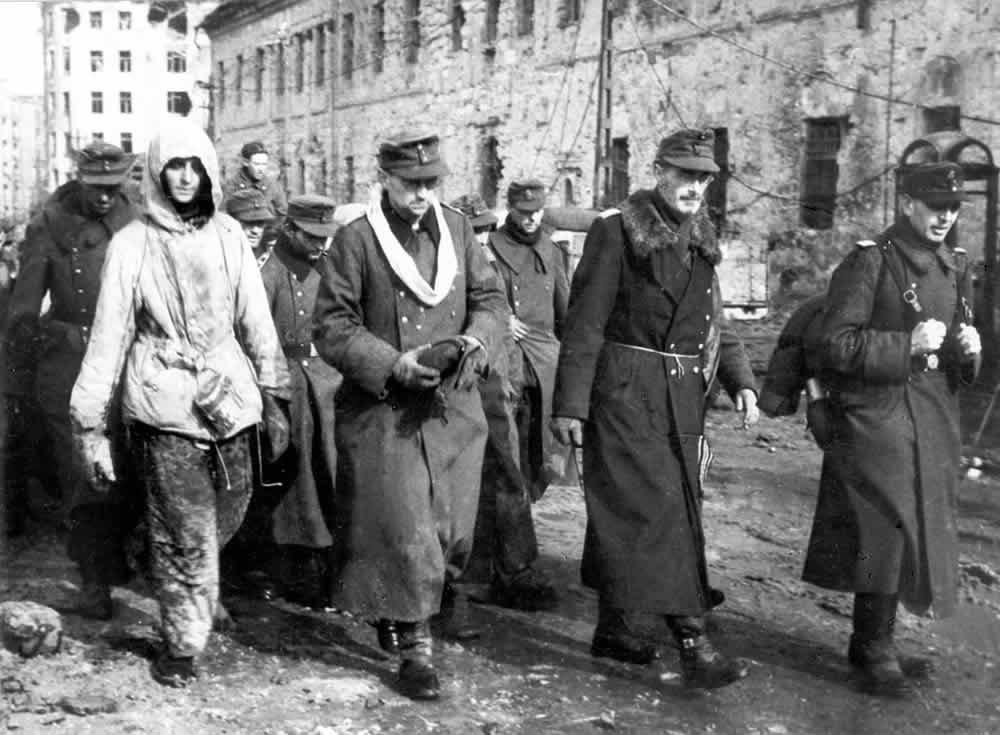A black-and-white photo of a column of German POWs captured in Budapest walking on a street, February 1945.