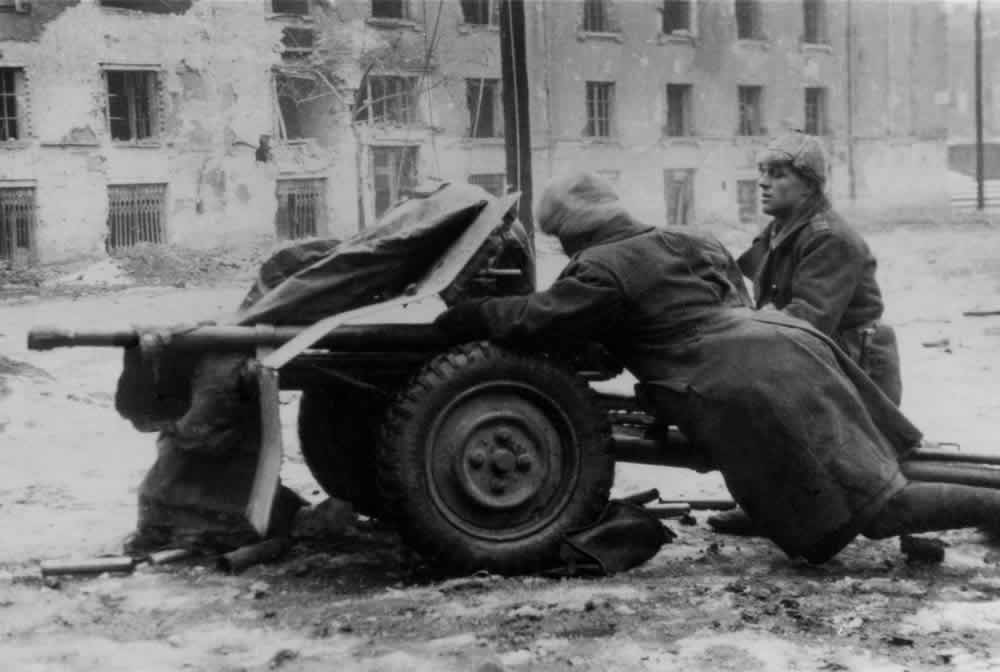 A black-and-white photo of a Romanian anti-tank gun manhandled by its crew on a Budapest street, early January 1945.